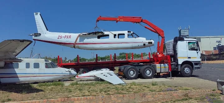 Crane truck loading an aircraft fuselage for transport