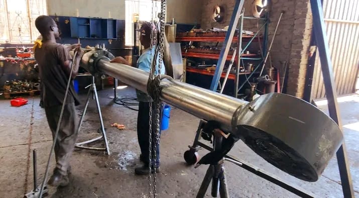 Technicians servicing a large hydraulic ram in the workshop